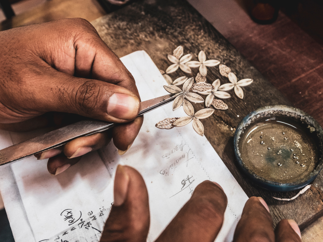 woman building a piece of jewelry with ancestral techniques with emeralds from Colombia to sell it in a jewelry store and export it to other countries. 