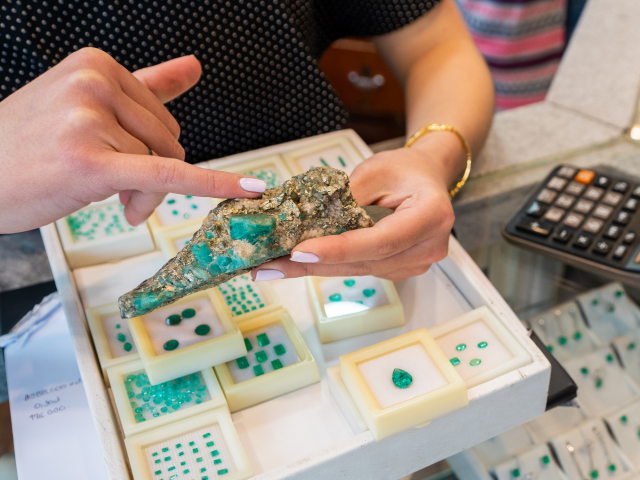 woman selling emerald jewelry from Colombia in a jewelry store that sells high quality emeralds.